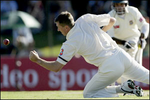 Australian bowler Glenn McGrath stops a drive from Bangladesh's Javed Omar during the first Test at Darwin