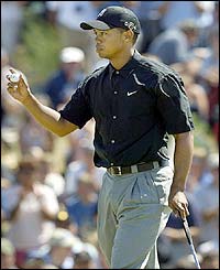 Tiger Woods acknowledges a birdie on the second