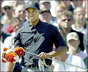 Tiger Woods takes a cover off one of his clubs