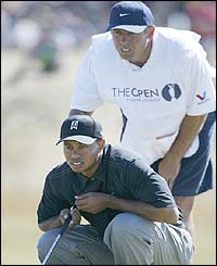 Woods and his caddy line up a putt