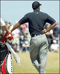 Tiger leans on his golf bag