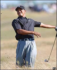 Woods plays a shot out of the rough on the 13th