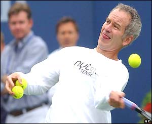 John McEnroe hits some balls into the stands during a rain delay