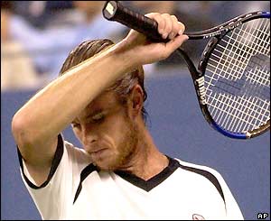 Xavier Malisse wipes his brow before serving to Andy Roddick
