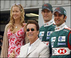 Kristanna Loken and Arnold Schwarzenegger stand with Jaguar drivers Mark Webber and Antonia Pizzonia