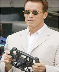 Arnold Schwarzenegger holds a steering wheel