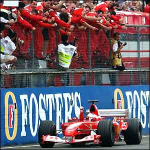 Rubens Barrichello drives past the celebrating Ferrari mechanics after winning the British Grand Prix