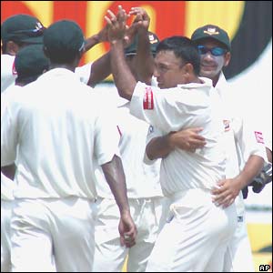 Bangladesh captain Khaled Mahmud (without cap) is congratulated on his 4-37