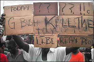 A man carries a placard reading 'Today G Bush kill the Liberian people' near the US embassy 