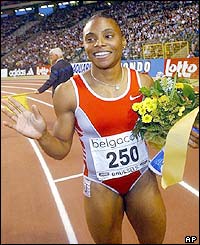 America's Kelli White waves after her 100m win