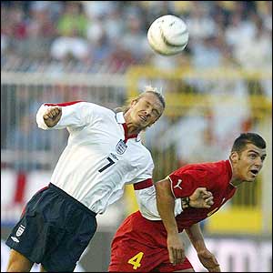 David Beckham wins a header against Pandev Goran 