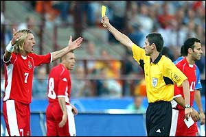 Robbie Savage is shown the yellow card by German referee Markus Merk