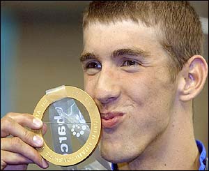 Michael Phelps kisses a gold medal