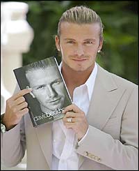 David Beckham holds up his autobiography