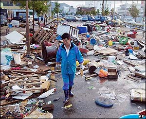 Man walks by scattered debris hit Msan