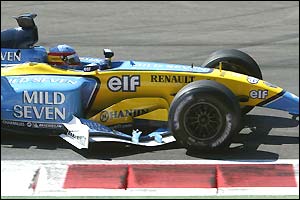 Fernando Alonso drives with his front wing jammed under the car