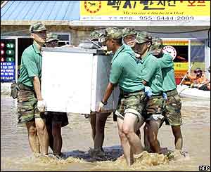 South Korean soldiers move a refrigerator out from a flooded house in Goryung 