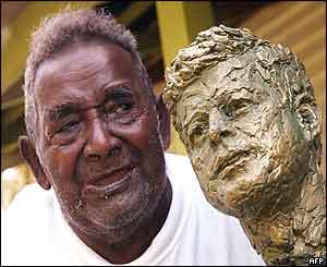 Biuku Gasa proudly displays the bronze bust of John F Kennedy presented to him by the Kennedy family