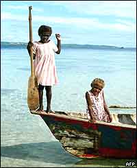 Children use an old timber canoe to reach the shores of Kennedy Island 