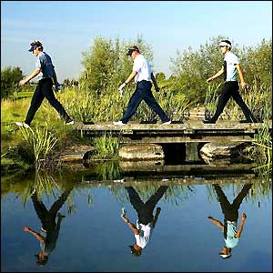 Poulter, Montgomerie and Jacobson walk over a bridge on the 17th hole