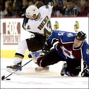 Brad Larsen gets trips by Phillipe Boucher in a pre-season NHL game