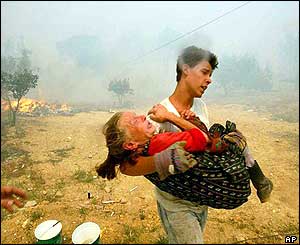 Man carries elderly woman to safety as smoke clogs the air