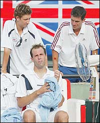 Great Britain's Alex Bogdanovic and Tim Henman stand above Greg Rusedski in his match in the Davis Cup against Morocco