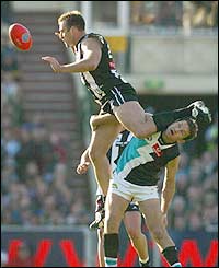 Collingwood Magpies' Anthony Rocca leaps high in the ruck over Port Adelaide Power's Brendon Lade during the AFL Second Preliminary Final at the MCG 