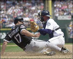 Tony Graffanino of the Chicago White Sox, scores the first run of the game in the fifth inning against catcher Dan Wilson of the Seattle Mariners 