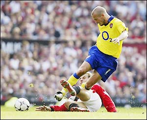 Man Utd's Phil Neville tries to stop Arsenal's Freddie Ljungberg pushing forward