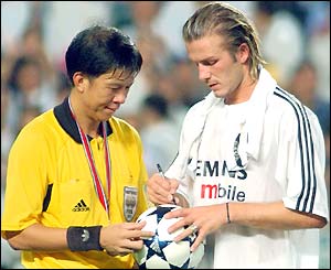 Another surreal moment for David Beckham as he signs the match ball for the referee