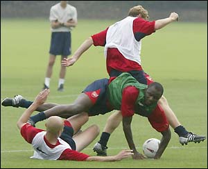 Pascal Cygan clatters Arsenal team-mate Patrick Vieira in training as the Gunners prepare for Sunday's Community Shield match against Manchester United