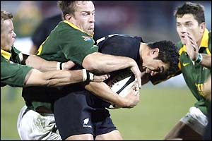 All Black Mils Muliaina is tackled by the South Africa defence
