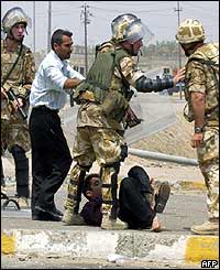 Iraqi youth being arrested down on the ground