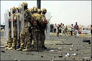 British soldiers stand back-to-back with riot shields