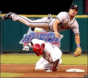 Marcus Giles goes airborne to avoid a sliding Edgar Renteria