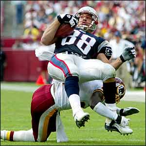 New England Patriots' Christian Fauria is sent flying by the Washington Redskins' Champ Bailey