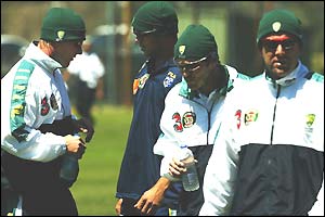 Brett Lee, Andrew Symonds, Damien Martyn and Darren Lehmann wearing woolly hats and tracksuits 