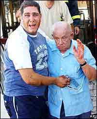 An elderly man being taken away from the scene