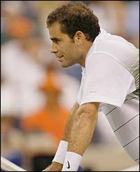 Pete Sampras leans on the net after missing a point