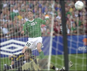 Robbie Keane sees his shot fly just wide of the post past diving Australian goalkeeper Mark Schwarzer
