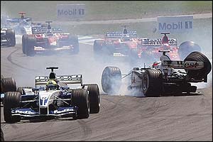 Ralf Schumacher steers his damaged car out of the way as Kimi Raikkonen spins out of the German Grand Prix