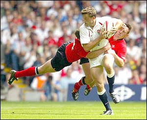 Dan Luger is tackled by two Wales players