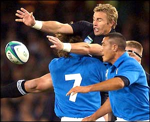 Justin Marshall of New Zealand is tackled by Italy's Mauro Bergamasco