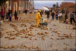 A street vendor on a road in El Alto blocked by thousands of stones 