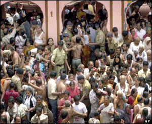 Police try to control pilgrims taking a dip in the river Godavari at the Kumbh Mela in Nasik