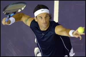 Spain's Carlos Moya serves to his fellow countryman opponent Feliciano Lopez during their Madrid Masters Series third round match