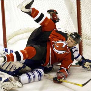 Eric Rasmussen of the New Jersey Devils falls in to the goal against the Toronto Maple Leafs