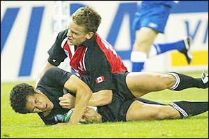 Mils Muliaina of New Zealand scores a try as Matt King of Canada attempts a tackle 