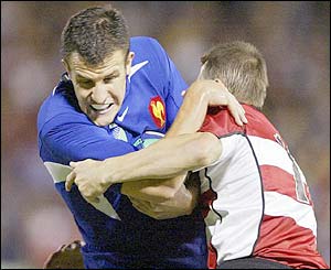 French centre Damien Traille is tackled by Japanese prop Shin Hasegawa 